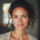 Femme souriante aux cheveux bouclés, ambiance chaleureuse.